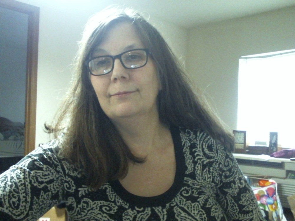 a-middle-aged-brunette-woman-in-glasses-wearing-a-black-and-white-print-top