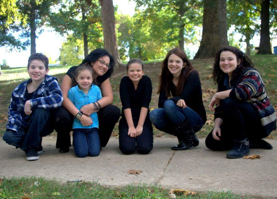 Pic of me black hair & mixed skin in all black & my 5 kiddos outside