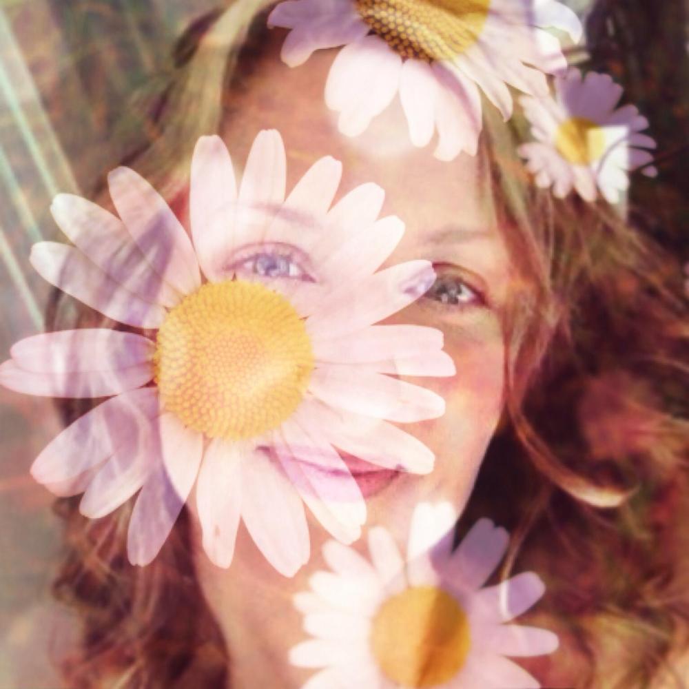 blond-hazel-eyed-woman-behind-a-transparent-layer-of-daisies