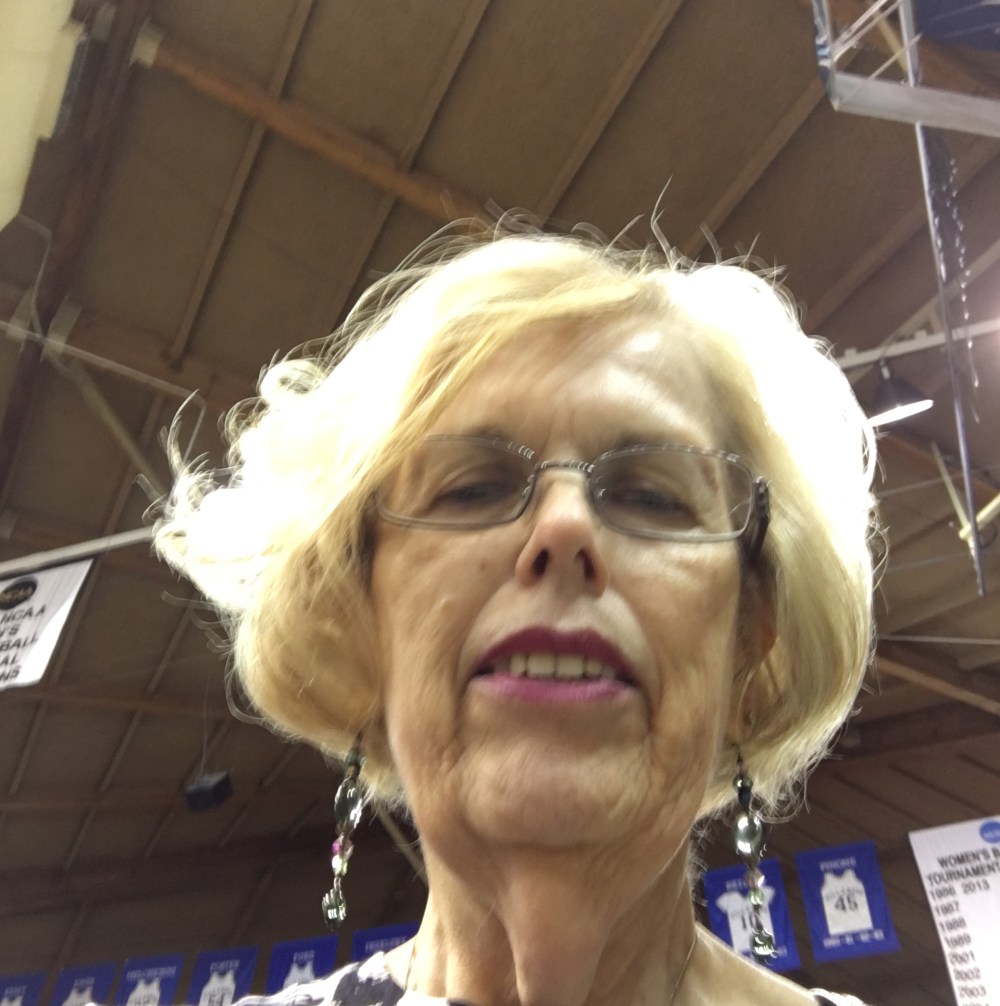  Blond older woman with glasses.  You can tell I'm in an arena.