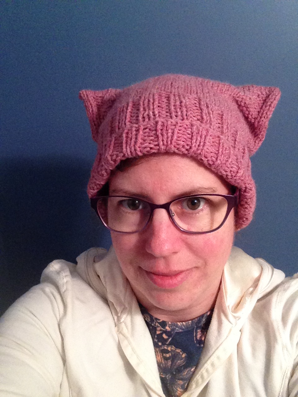 headshot-of-woman-with-glasses-and-a-pink-knitted-pussyhat