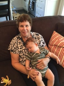 Grandmother sitting on a cough embracing her grandson. 
