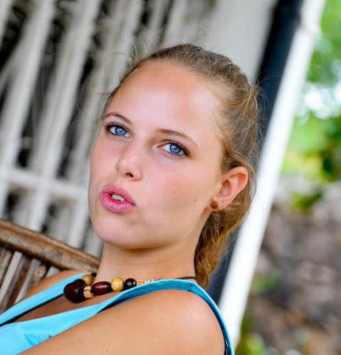 Headshot of a young woman in a blue tanktop. 