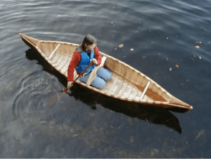 A woman sitting in a canoe in the water, seen from above