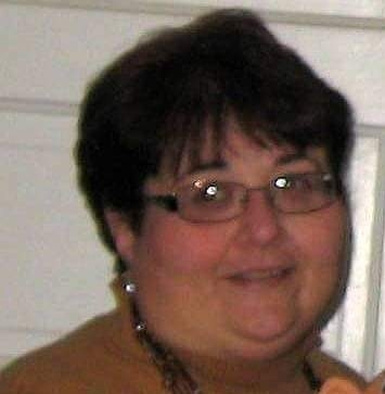 Headshot of Terry, sporting a short dark haircut and glasses. She smiles and looks at the camera.